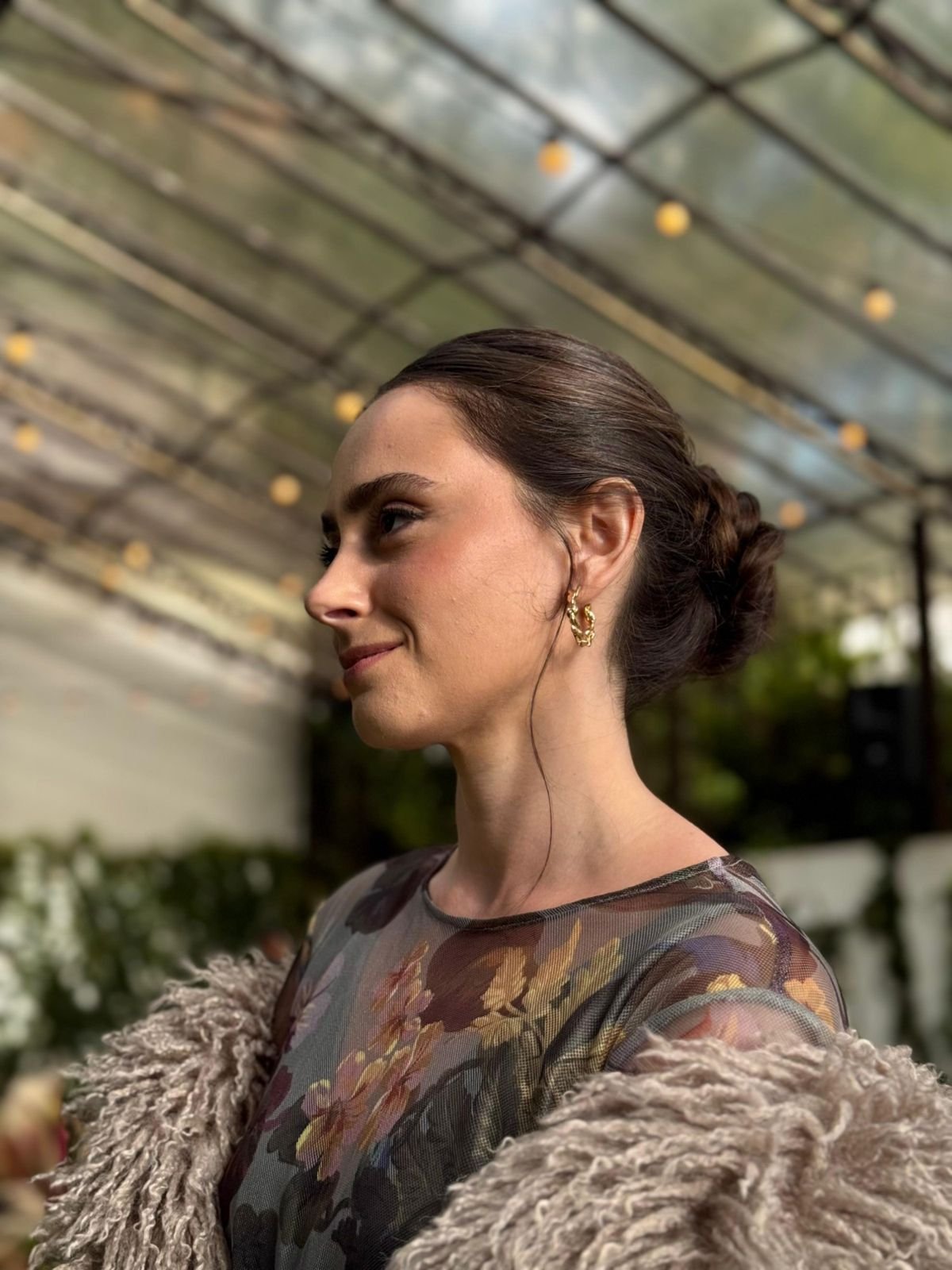 Perfil sob luzes suspensas, com argola dourada